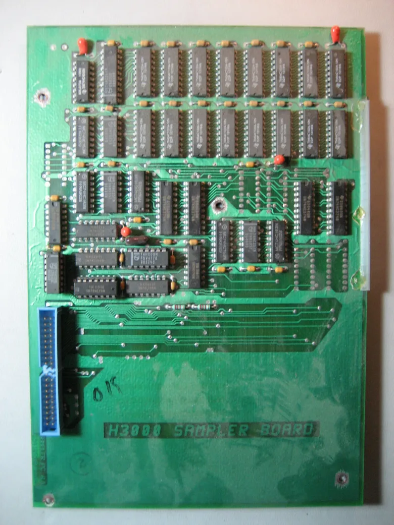 A green board with rows of chips and “H3000 SAMPLER BOARD” silkscreen lettering.