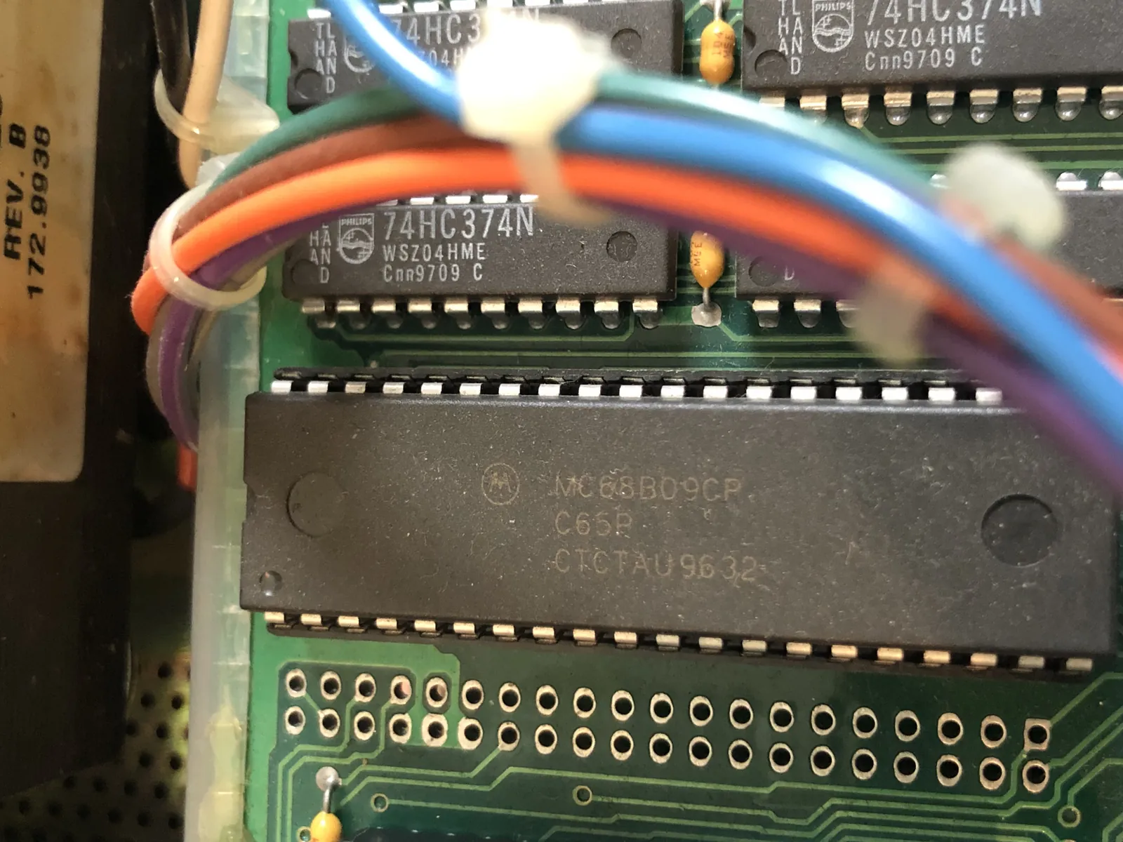 A long chip with the Motorola logo and MC68B09CP marking, with a bundle of wires above.