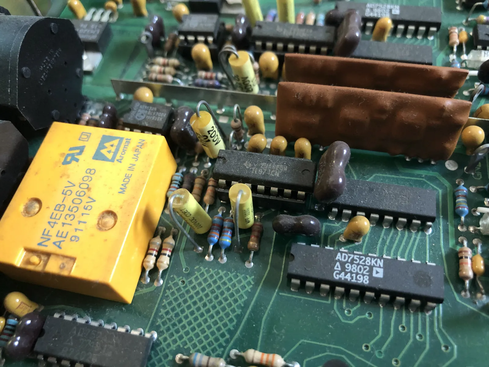 A yellow rectangular relay marked Aromat and NF4EB-5V. A brown module and an AD7528KN chip sit to the right.
